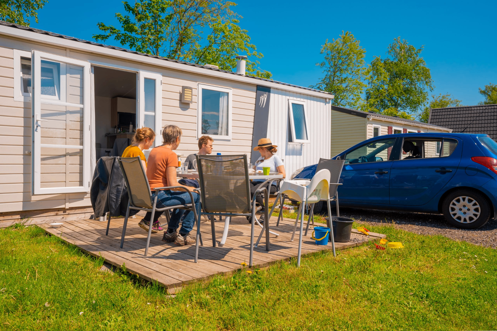 Familie spiser på terrassen ved et mobile home på Lægårdens Camping
